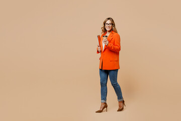 Sticker - Full body young business woman corporate lawyer wear classic formal orange suit glasses work in office hold documents takeaway delivery craft brown cup coffee to go isolated on plain beige background.