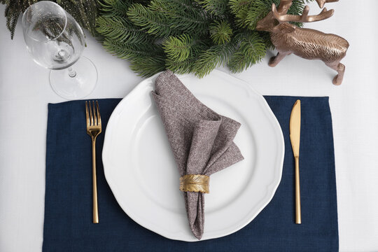 Festive place setting with beautiful dishware, cutlery and fabric napkin for Christmas dinner on white table, flat lay