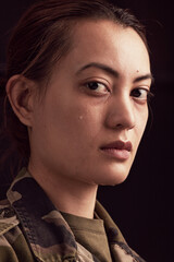 Crying, soldier trauma and face of sad woman with depression, military ptsd and trauma from army service on studio black background. Portrait of depressed young female veteran with tears from battle