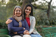 Two indian woman sitting at park in winter wear.