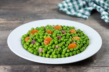 Wall Mural - Green peas with serrano ham and carrot on wooden table