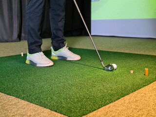 Wall Mural - Professional male golfer playing golf indoors in golf simulator closeup