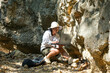 © Pornpimon - Female geologist using laptop computer examining nature, analyzing rocks or pebbles. Researchers collect samples of biological materials. Environmental and ecology research.