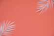 Leinwandbild Motiv Tropical palm leaf on red background. Flat lay, top view	