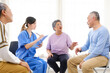 © artitwpd - The caregiver therapist sits with a group of Asian senior people in a circle for checking physical and mental health in a group elderly therapy session. The nursing home facilitates a support group