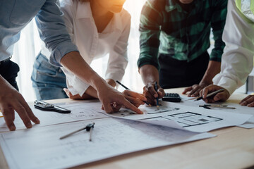 Cropped view of team engineers checking new construction project blueprints with engineering tools at work desk in office