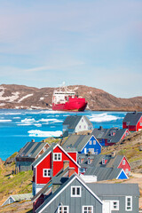 Wall Mural - Arctic ship leaving Tasiilaq after having unloaded at the docks in the harbour - Tasiilaq, Greenland