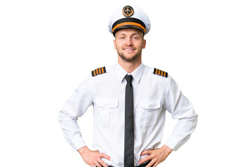 Wall Mural - Airplane pilot man over isolated background posing with arms at hip and smiling