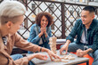 © zinkevych - Joyous company employee observing her coworkers playing a board game