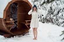 Portrait of caucasian woman standing in front of sauna wearing in bathrobe