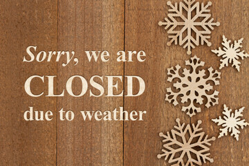 Wall Mural - Sorry we are closed due to weather sign with snowflakes on weathered wood
