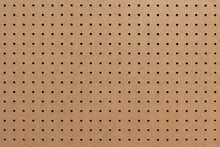 Abstract Background Of Brown Perforated Hardboard Sheet, Plywood With Pre-drilled With Evenly Spaced Holes Nature Seamless Pattern Texture, Surface And Details Of Brown Wood Plank.