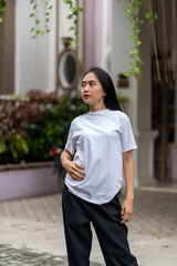 Wall Mural - A young woman with a white blank shirt doing a cool pose with the with out of focus background