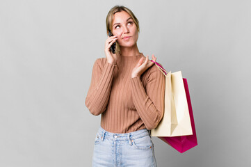 Wall Mural - pretty caucasian woman with shopping bags and a smartphone