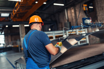 Factory worker bending steel at the machine