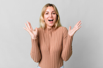 Wall Mural - caucasian blonde woman feeling happy and astonished at something unbelievable