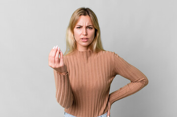 Wall Mural - caucasian blonde woman making capice or money gesture, telling you to pay