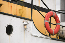 Near A Porthole, A Lifering Hangs On The Railing Of A Ship.; Petersburg, Mitkof Island, Alaska