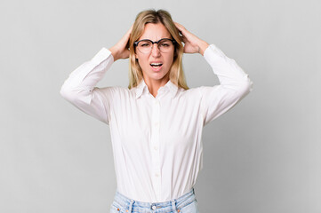 Wall Mural - caucasian blonde woman feeling stressed, anxious or scared, with hands on head