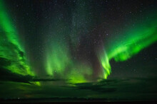 Aurora Borealis With Sheets Of Bright Green Light Fluttering Across The Night Sky; Iceland