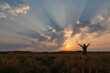 © Designpics - Corpuscular rays during sunrise over the prairies of Saskatchewan. Woman standing and rejoicing in the beauty of a new day; Saskatchewan, Canada