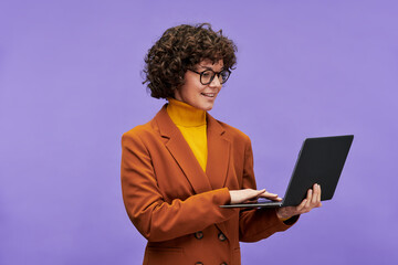 Poster - Young confident brunette female teacher or chief executive officer in formalwear holding laptop and looking at screen during network