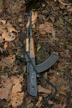 Machine Gun Lying In Leaf Litter On The Ground, Belonging To A National Park Guard In Queen Elizabeth National Park, Uganda, Africa; Uganda
