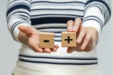 Pros And Cons, A Woman Holds Wooden Blocks With A Positive And Negative Symbol In Her Hands, The Concept Of Pros And Cons, Ups And Downs