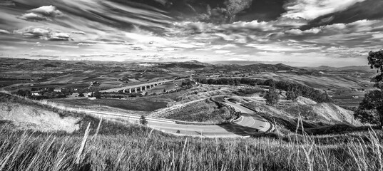 Wall Mural - Panoramic view at curved mountain road under the mountain peak. Black and white
