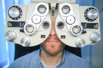 Wall Mural - Adult man eyesight test with binocular slit-lamp. Checking retina of a male eye close-up. Ophthalmology Clinic