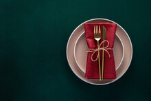 Dinner Table Setting With Empty Plates And Golden Cutlery On Dark Green Background, Card Or Menu Template With Copy Space For Text, Flat Lay Design. Top View. Modern Ceramic Crockery, Trendy Tableware