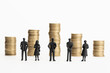 © Formatoriginal - Group of figurines looking at stacks of coins