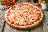 Fototapeta  - Pizza with ham and mushrooms with tomato sauce on wooden table, close up