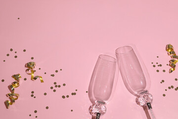 pink background with two champagne glasses and space for text, harsh shadows, new years eve celebrat