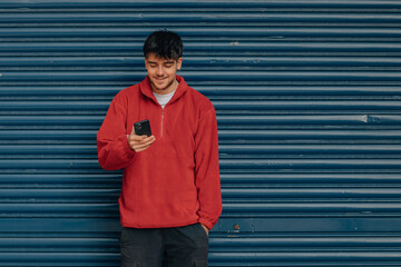 Wall Mural - young man with mobile phone in the street with copy-space