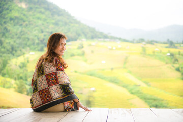 Poster - Asian female tourist sitting on the patio enjoying the natural view of Rice terraces in Chiang Mai Province