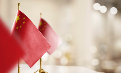 Small flags of the China on an abstract blurry background