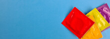 Multicolored Condoms On Blue Background. Advertising Means Of Contraception