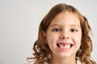 Close-up portrait of a child girl without one tooth
