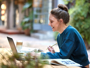 Woman, laptop and student study at cafe with smile for education, learning or writing in the outdoors. Happy female at internet coffee shop in remote working or elearning on computer for assignment