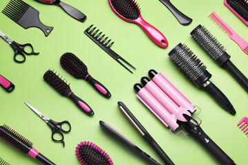 Flat lay composition of different professional hairdresser tools on light green background