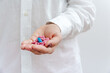 © Kolomiiets Viktoriia - Women's hand with pills. Medical insurance, medical treatment concept. Disease, sick treatment, cold season concept. Close-up view