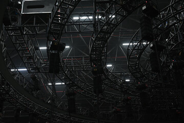 Dark background with trusses and winches. Exhibition ceiling with truss. Industrial background