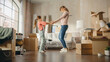 © Gorodenkoff - Truly Happy Mother and Daughter Moving Into their New Cozy Home. Cheerful Young Family, Girls Have Fun, Dance, Hug in the Middle of Apartment. Living Room Has Unpacked Cardboard Boxes.