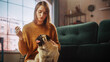© Gorodenkoff - Portrait of Beautiful Young Woman Cuddles Her Adorable Little Pug at Home. Girl Plays with Her Dog, Best Friend. She Pets and Scratches Super Happy Doggy, Have Fun in the Living Room