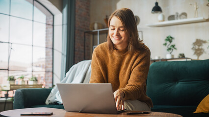 Fototapete - Young Beautiful Woman Working from Home on Laptop Computer Sunny Stylish Loft Apartment. Successful Creative Female Entrepreneur Does Remote Work e-Commerce, e-Business Project, Software Development