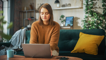 Poster - Portrait of Smiling Young Woman Working from Home on Laptop Computer in Sunny Cozy Apartment. Successful Creative Girl Entrepreneur Does Remote for e-Business Project, Online Shopping