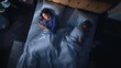 © Gorodenkoff - Top View: Young Woman Uses Smartphone in Bed at Night When Her Male Partner Trying to Fall Asleep Beside. Couple Fight, Argue. Addictive World of Social Media, Doom Scrolling, Fake News.