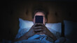© Gorodenkoff - Anonymous Man Uses Smartphone in Bed at Home at Night. Handsome Guy Browsing Social Media, Reading News, Doing Online Shopping Late at Night. Focus on Hand Holding Mobile Phone Covering Face