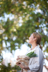 Woman, customer and grocery shopping with vegetables for natural eco friendly bag on mockup. Asian female shopper smiling holding healthy food for diet or green products for nutrition in nature